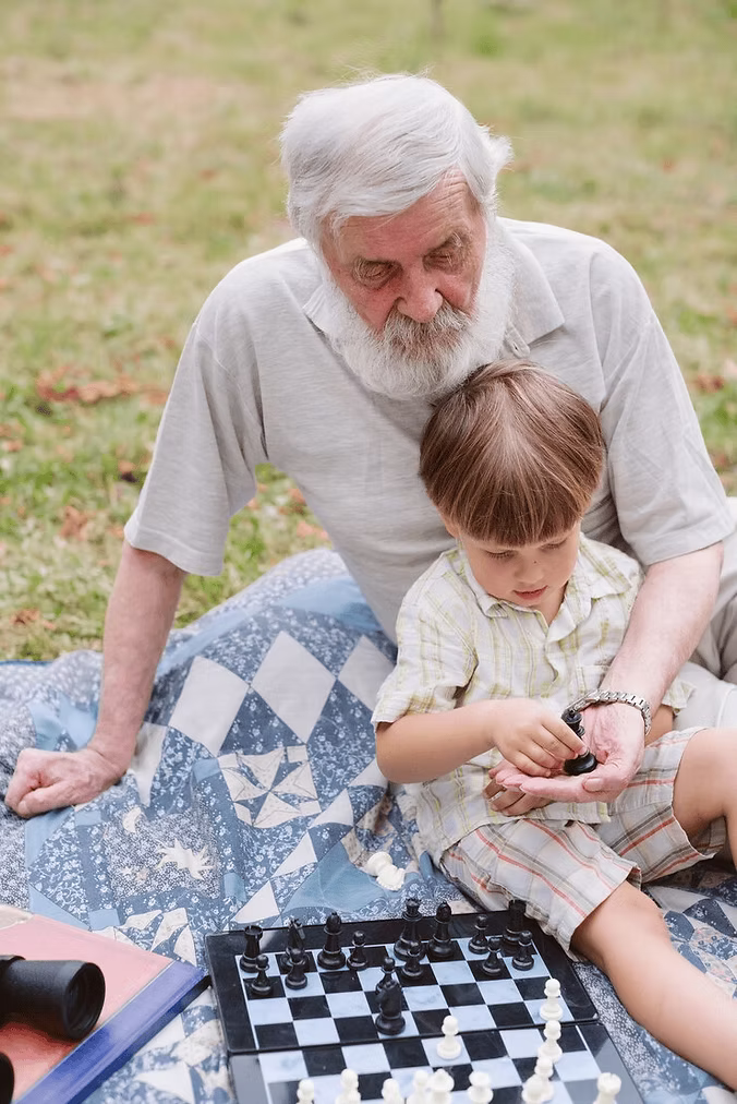 Grandfather playing chess with grandchild